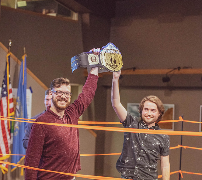 boys holding up winning belt