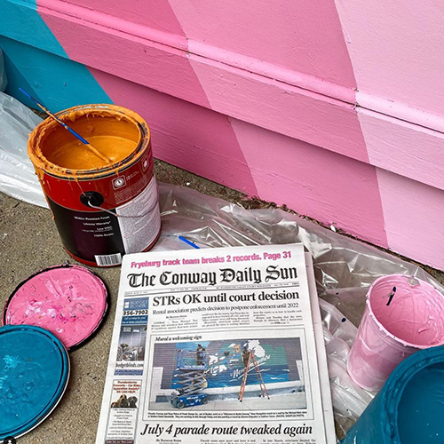 news paper next to open paint cans