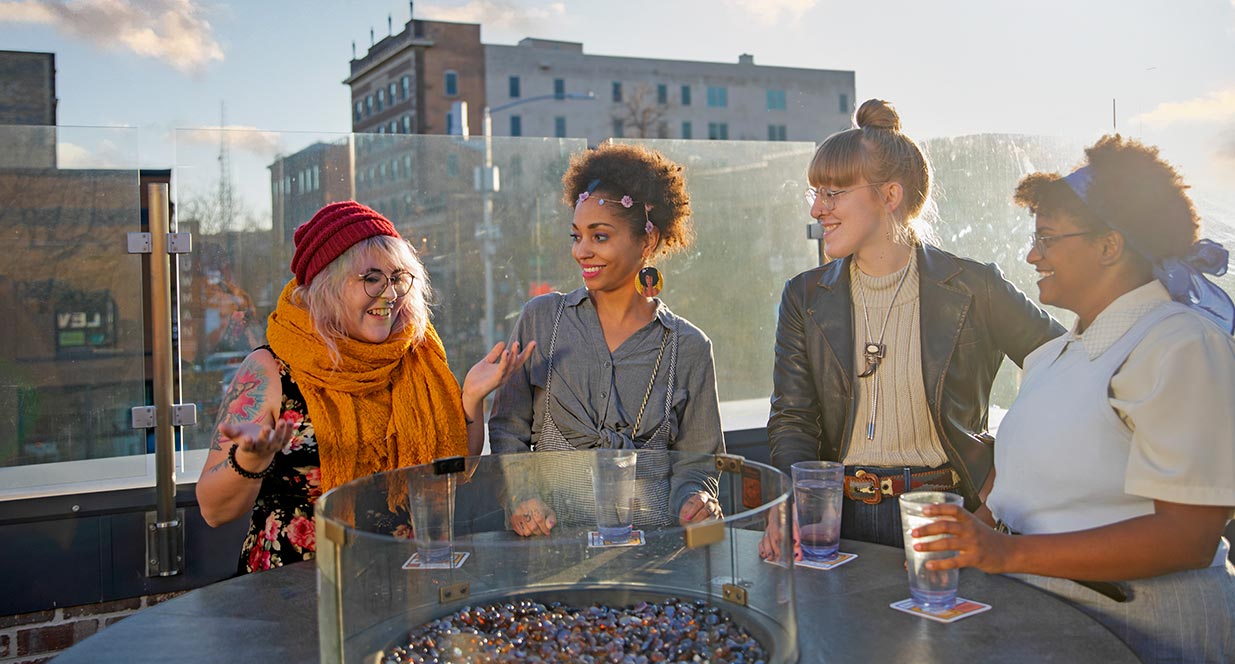 group of people on roof top sitting around a fire