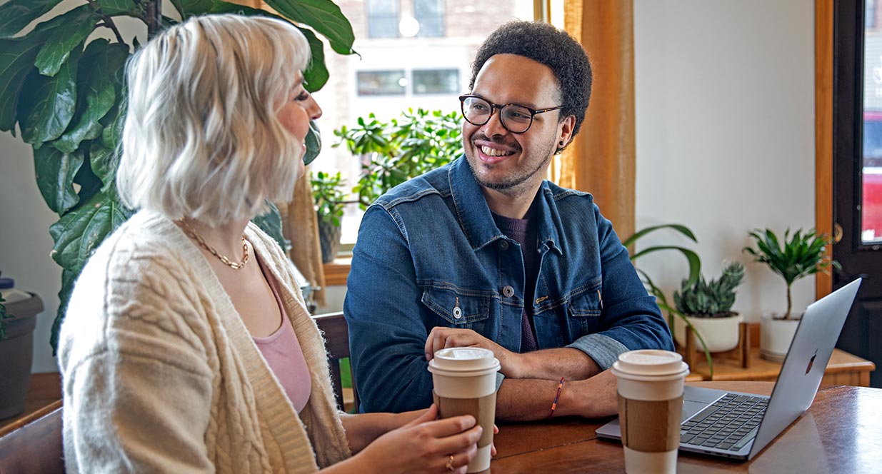 man and woman drinking coffees in a shop