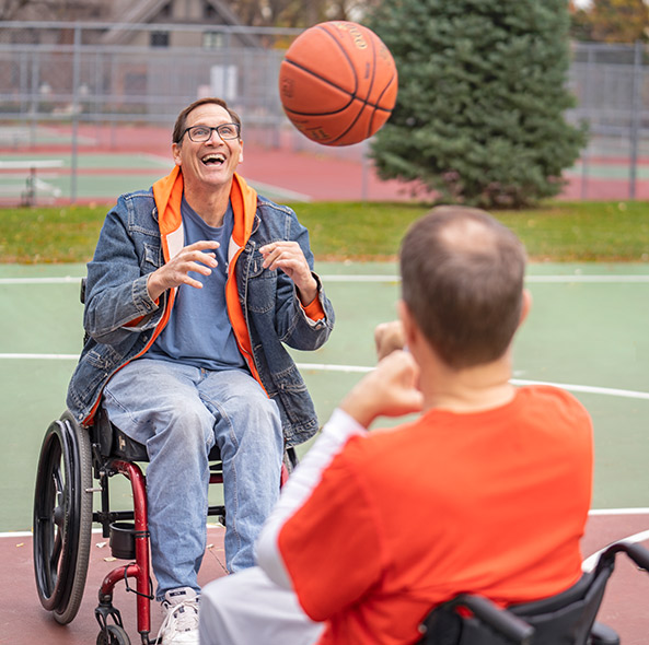 two men in wheelchairs playing basketball