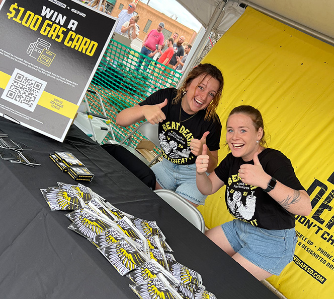 Two women smiling at a booth