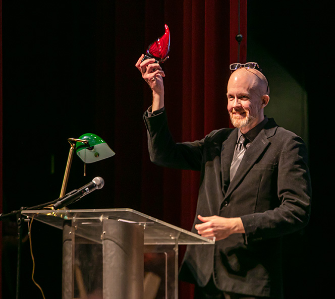 Wade Thurman holding an award in the air