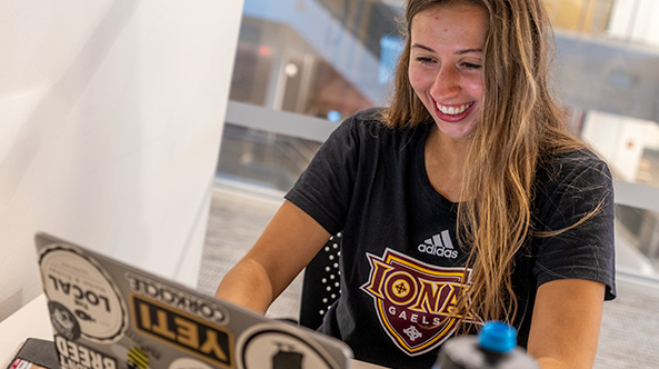 Student on her computer smiling