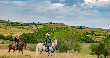 Two people riding horses