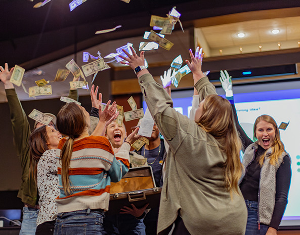 A group of people throwing cash into the air