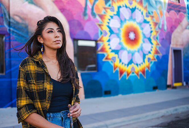 Woman standing in front of a mural