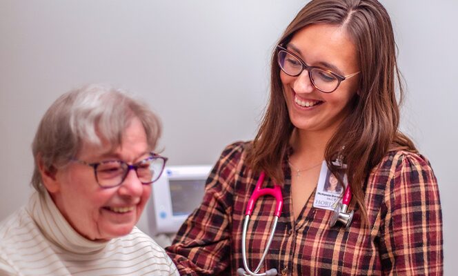 Female doctor smiling with female patient