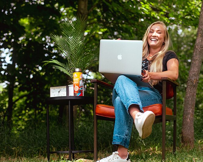 Young woman smiling while working on a laptop